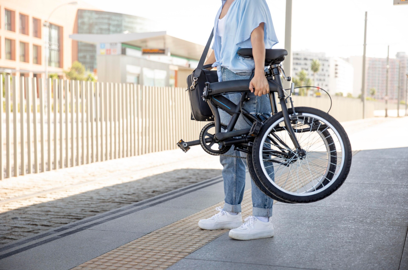 Une femme se rend au travail et transporte son vélo électrique pliant dans le métro