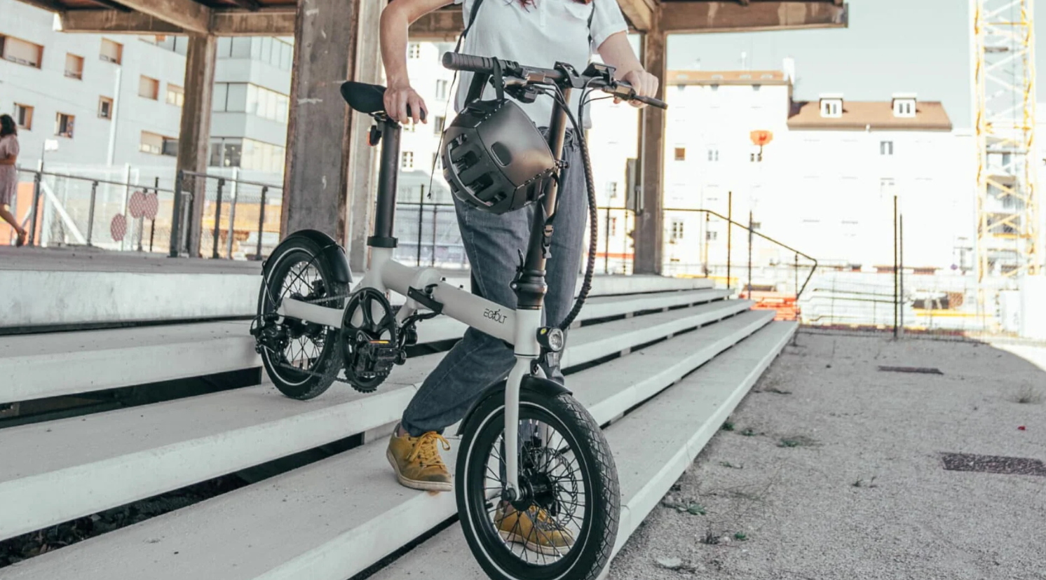 Une personne sort de la boutique ShiftBikes à Paris 18 avec son vélo électrique Pliant Eovolt